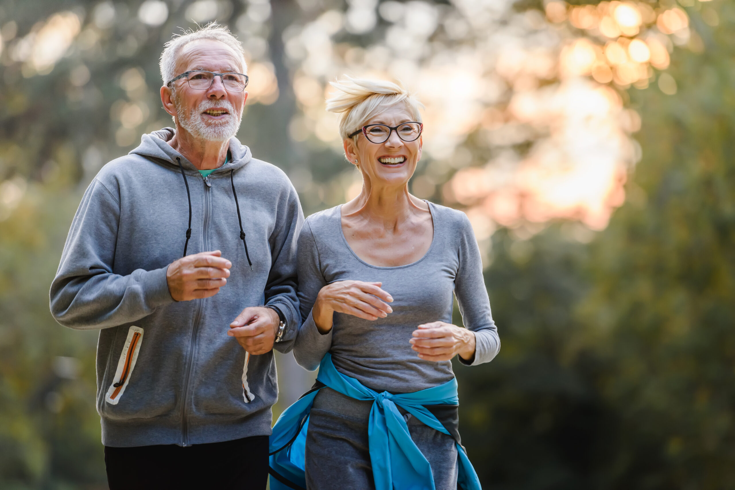 Mature couple jogging showcasing a healthy lifestyle when considering hearing aids